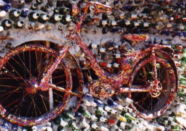 glass bottle house with bicycles junk