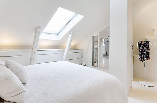 Breezy white bedroom with skylight