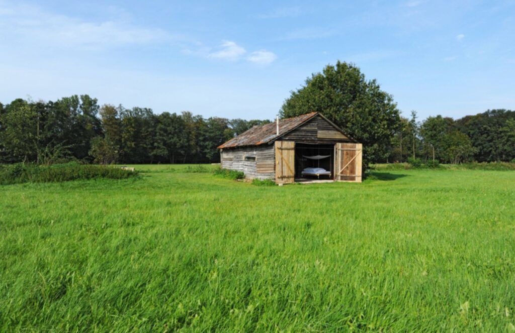 Low cost reclaimed barn residence in field