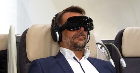 First-class passenger seated and wearing an Allosky VR headset.