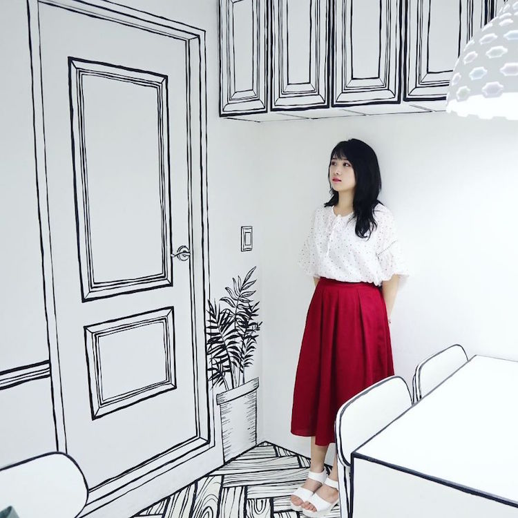 A young woman standing against a wall inside Café Yeonnam-dong.
