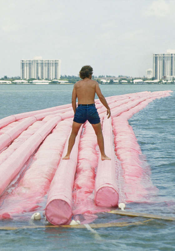 A man standing on the strand of pink fabric that runs through the "Surrounded Islands" installation. 