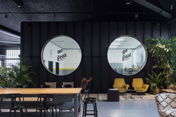 Two large porthole's inside the Filling Station Motel's concept store, with views into the adjacent workshop.