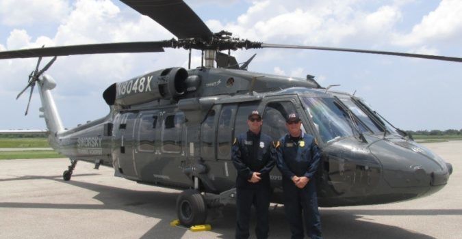 San Diego Fire-Rescue Senior Pilot Chris Hartnell (left) and Chief Chuck Macfarland standing by a Black Hawk "Fire Hawk."