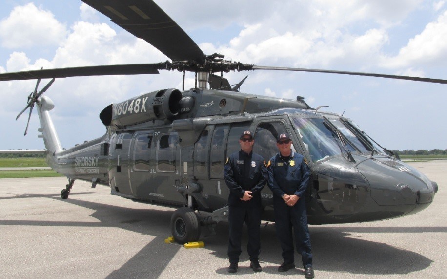 San Diego Fire-Rescue Senior Pilot Chris Hartnell (left) and Chief Chuck Macfarland standing by a Black Hawk "Fire Hawk." 