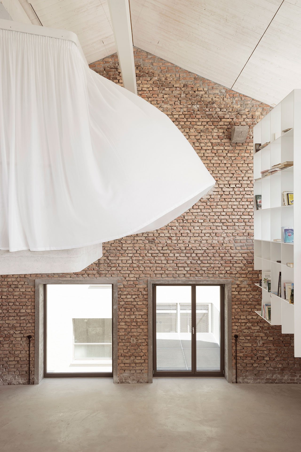 The white hanging bookcase located near the back of Loft Panzerhalle. 