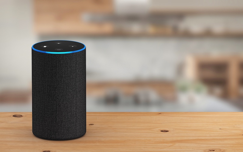A smart home voice assistant on a wooden kitchen table.