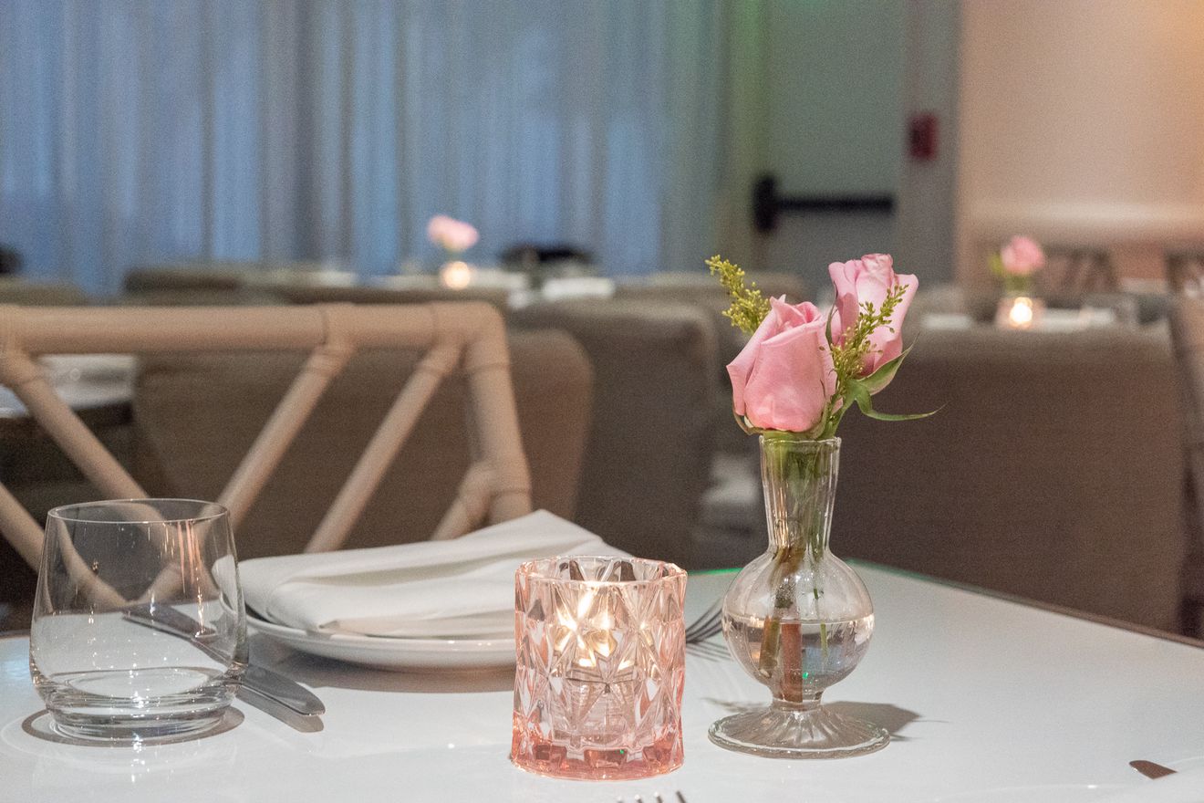 Pink flowers and a pink candle holder adorn each table in the Swan Restaurant.