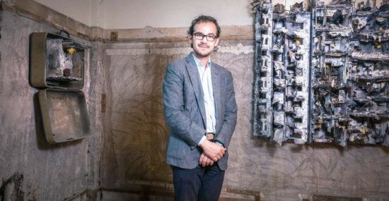Syrian artist Mohamad Hafez standing in front of his art.
