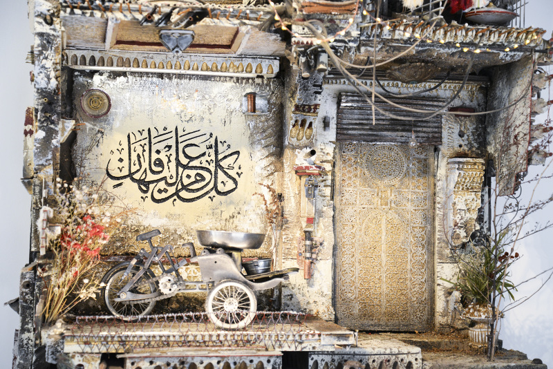 A sculpture by Mohamad Hafez depicting a makeshift motorcycle in front of Syrian writing.
