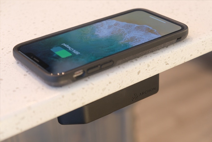 Phone charging on a tabletop using the Archon invisible wireless charger.