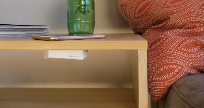 Phone charging on a tabletop using the Archon invisible wireless charger.