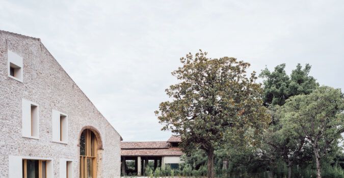 The exterior facade of "A Country Home in Chievo," with a swimming pool and magnolia tree visible in the foreground.