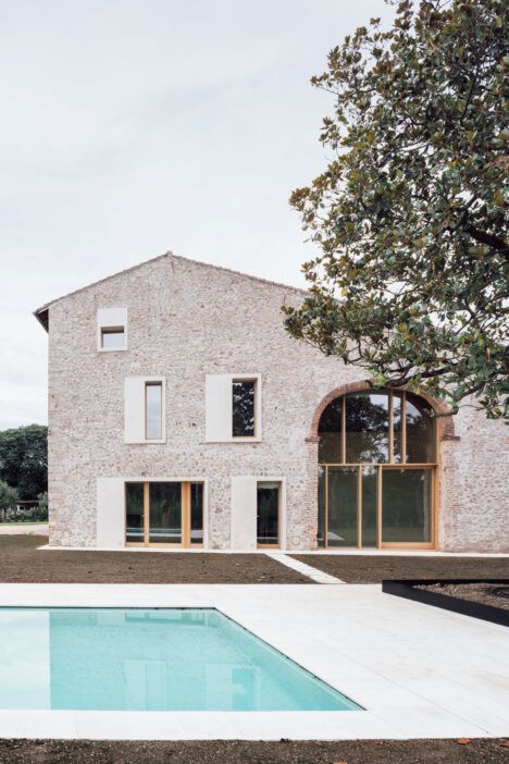 The exterior facade of "A Country Home in Chievo," with a swimming pool and magnolia tree visible in the foreground.