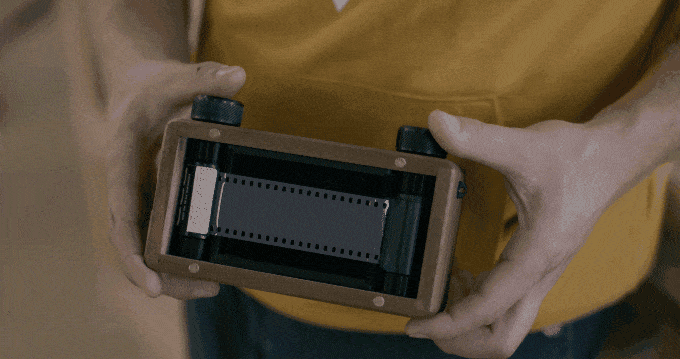 Person shows off the strip of film running along the back of the ONDU III Pinhole Camera.