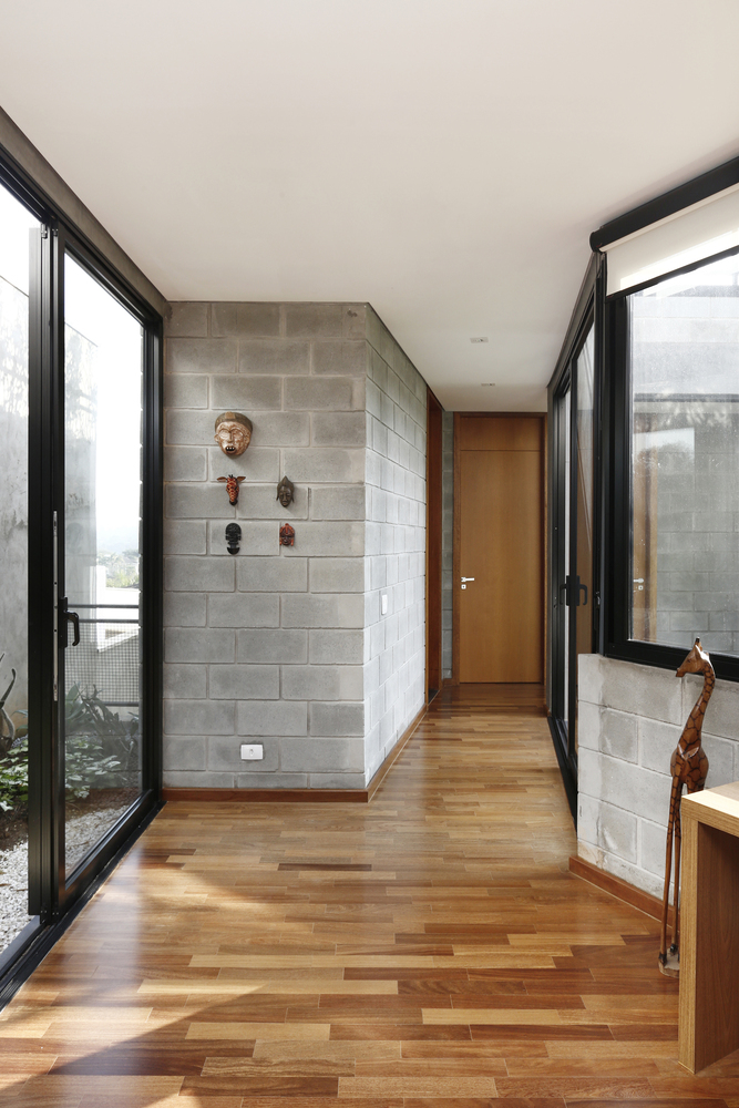 The sleek interior of the new RD House in Brazil, with wood, tile, and operable glazing all present in the decor scheme. 