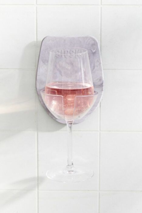 The Sipski Wine Glass Holder mounted to a shower wall, with a glass of rosé nestled firmly inside it.