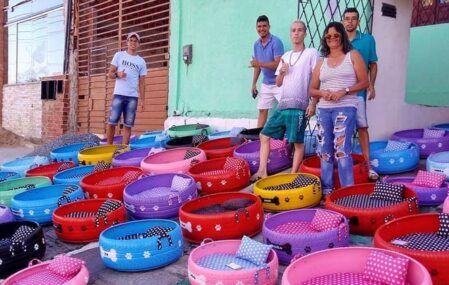 Brazilian craftsman Amarildo Silva's team, surrounded by their colorful upcycled dog beds.