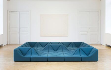 One of furniture designer Pierre Paulin's modern chairs sits in the middle of a large art gallery.