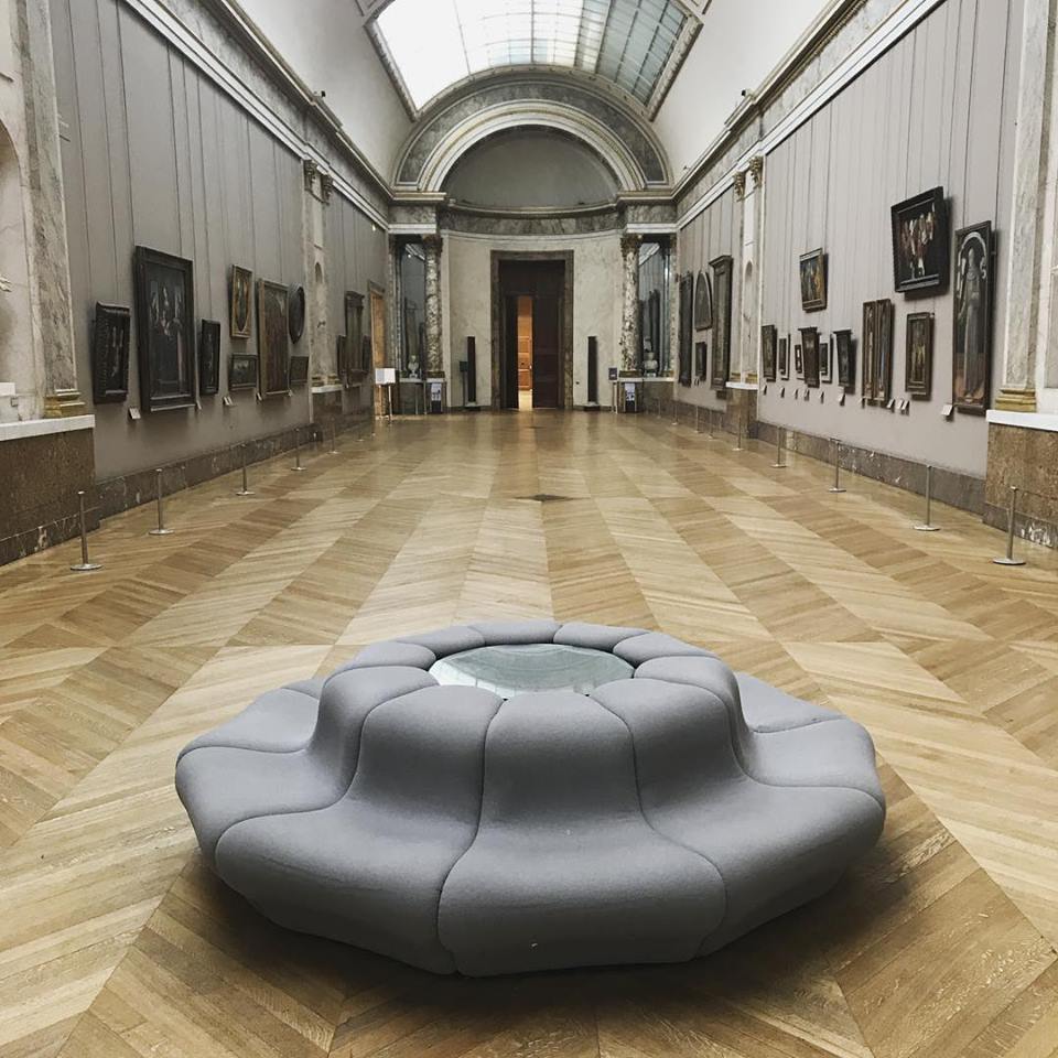 One of furniture designer Pierre Paulin's modern chairs sits in the middle of a large art gallery. 