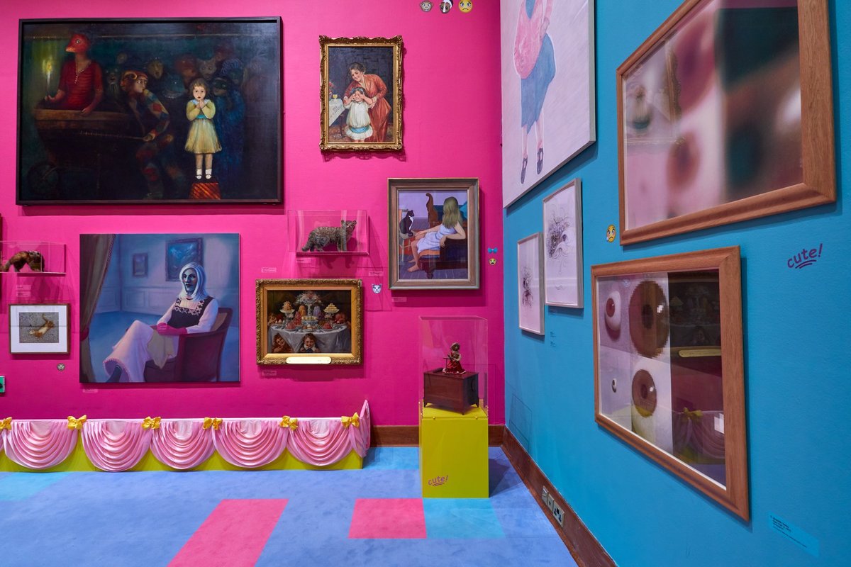 One of the galleries that make up Rachel Maclean's "Too Cute!" exhibit., with bright blues and pinks visible all around.