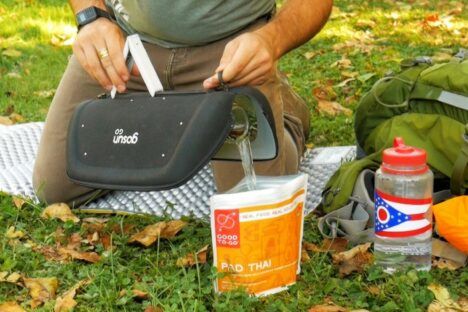 Man pours boiling water out of his GoSun Go Portable Solar Cooker.