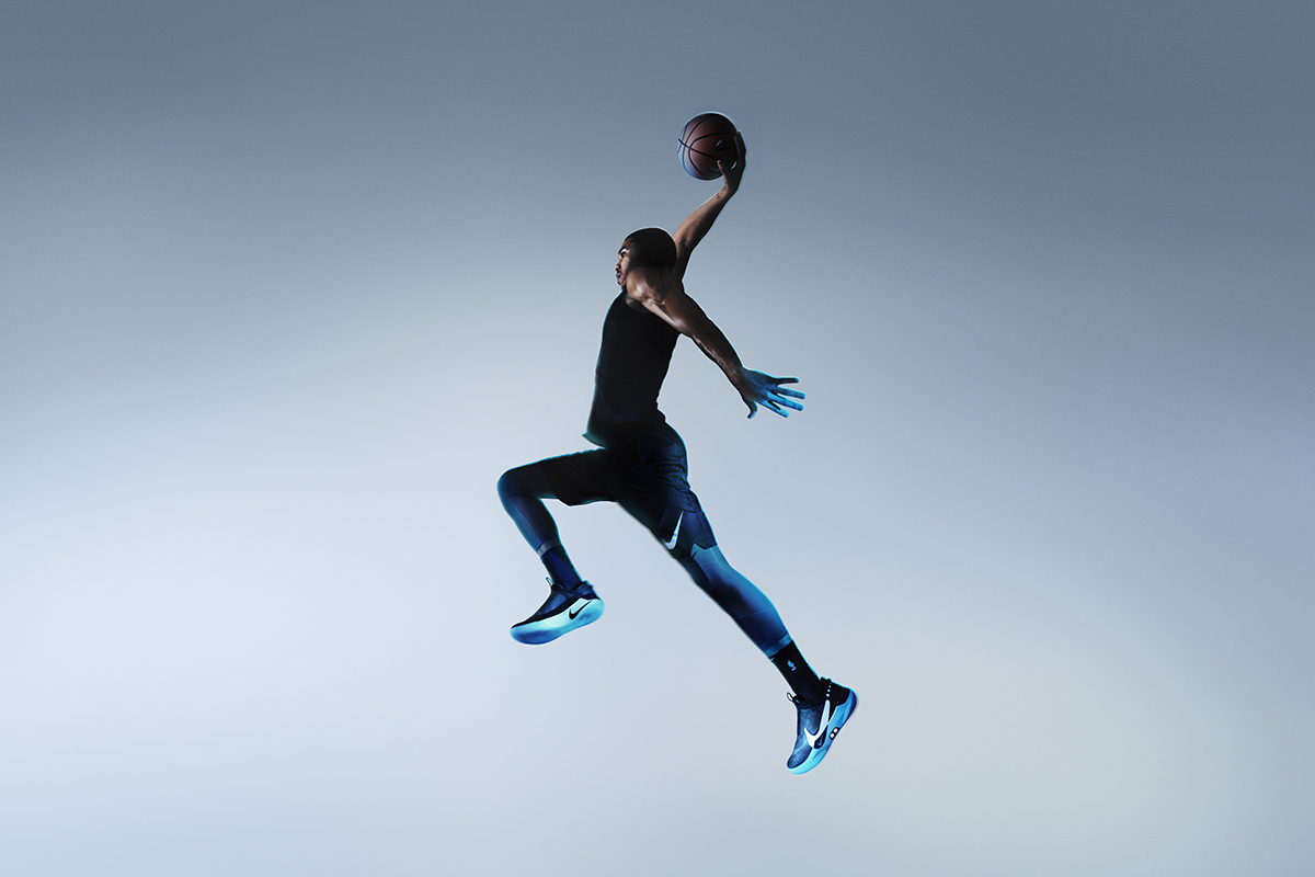 Athlete playing basketball while wearing the Adapt BB self-lacing sneakers. 