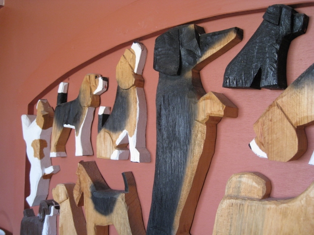 The headboard of the bed inside the Dog Bark Park Inn, into which several dogs have been carved. 
