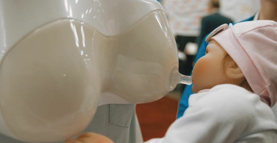 Baby suckles "Father’s Nursing Assistant,” a new silicone nursing device from Dentsu.