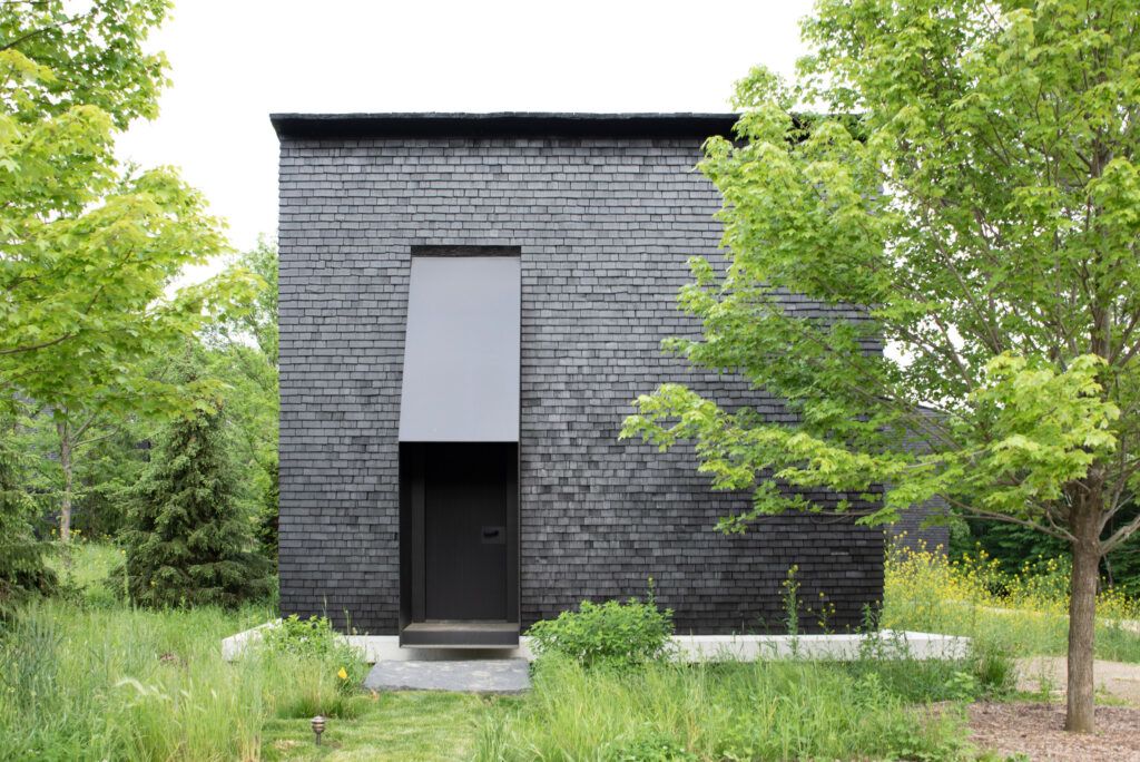 "Hudson Valley House II," a complex of stark black cottages in Upstate New York. 