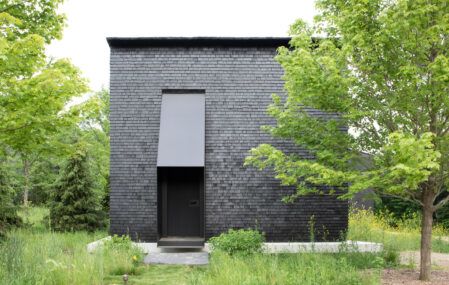 "Hudson Valley House II," a complex of stark black cottages in Upstate New York.