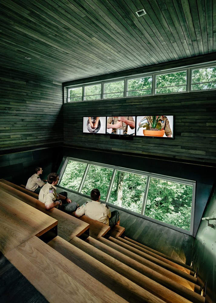 Scouts sit in a bleacher-style area inside the Sustainability Treehouse