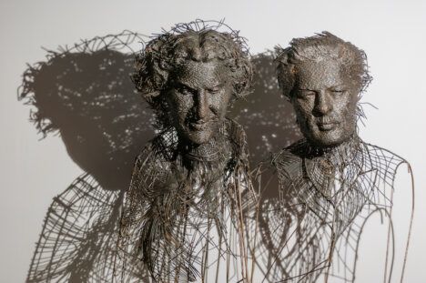 Metal wire sculptures of historic figures by artist Darius Hulea.
