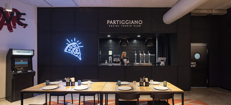 A hip modern space inside Partiggiano, complete with a neon pizza sign and old-school arcade game