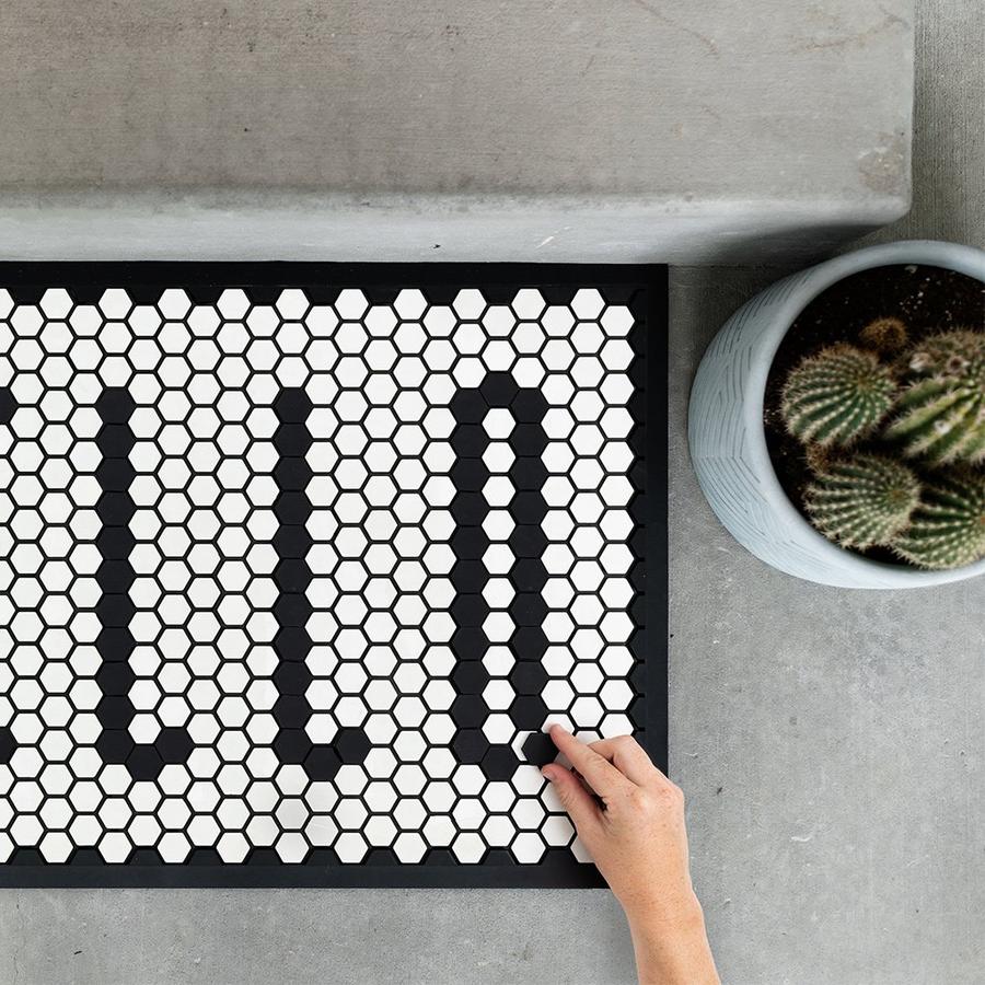 Hand moves the black tiles around to complete a Tile Mat message