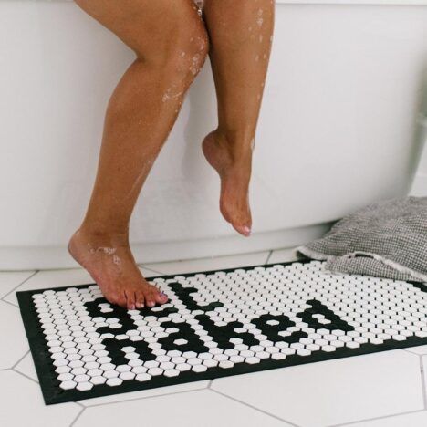 Person steps out of the shower onto their fun Tile Mat