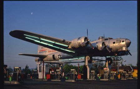 a gas station with a bomber plane on top