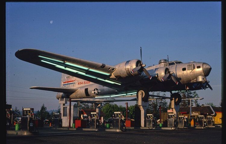 a gas station with a bomber plane on top