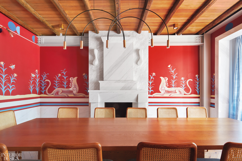 The dining area inside the renovated Hellas House, complete with bright red artworks and a beautiful stained wooden dining table.
