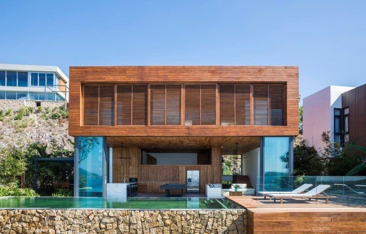 the front of a terrace house in Vietnam with wood paneling and a stone pool