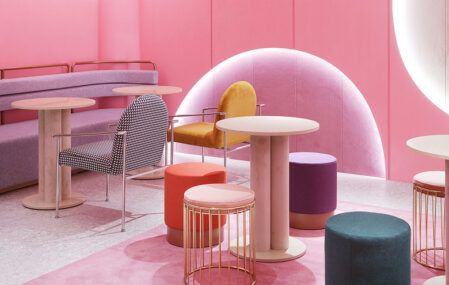 pink room with round tables and colorful stools