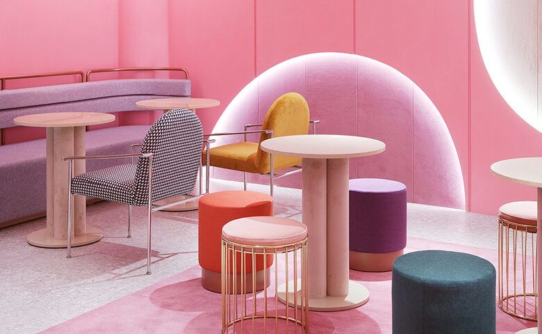 pink room with round tables and colorful stools