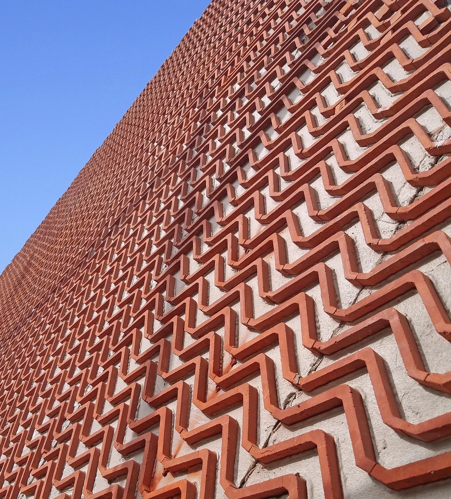 Exterior shot of a new home by Manoj Patel Design Studio, which uses clay tiles to promote passive heating and cooling