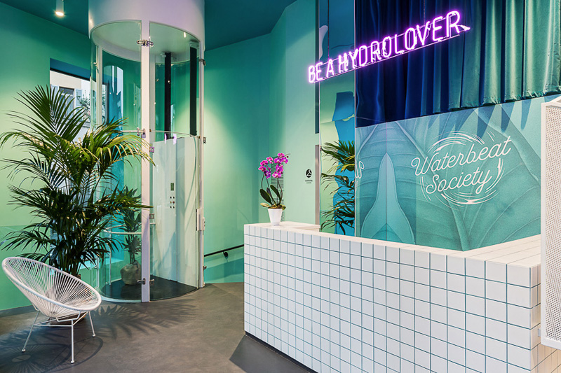 Waterbeat Society's trendy reception area, complete with neon signs and lots of sleek white tile